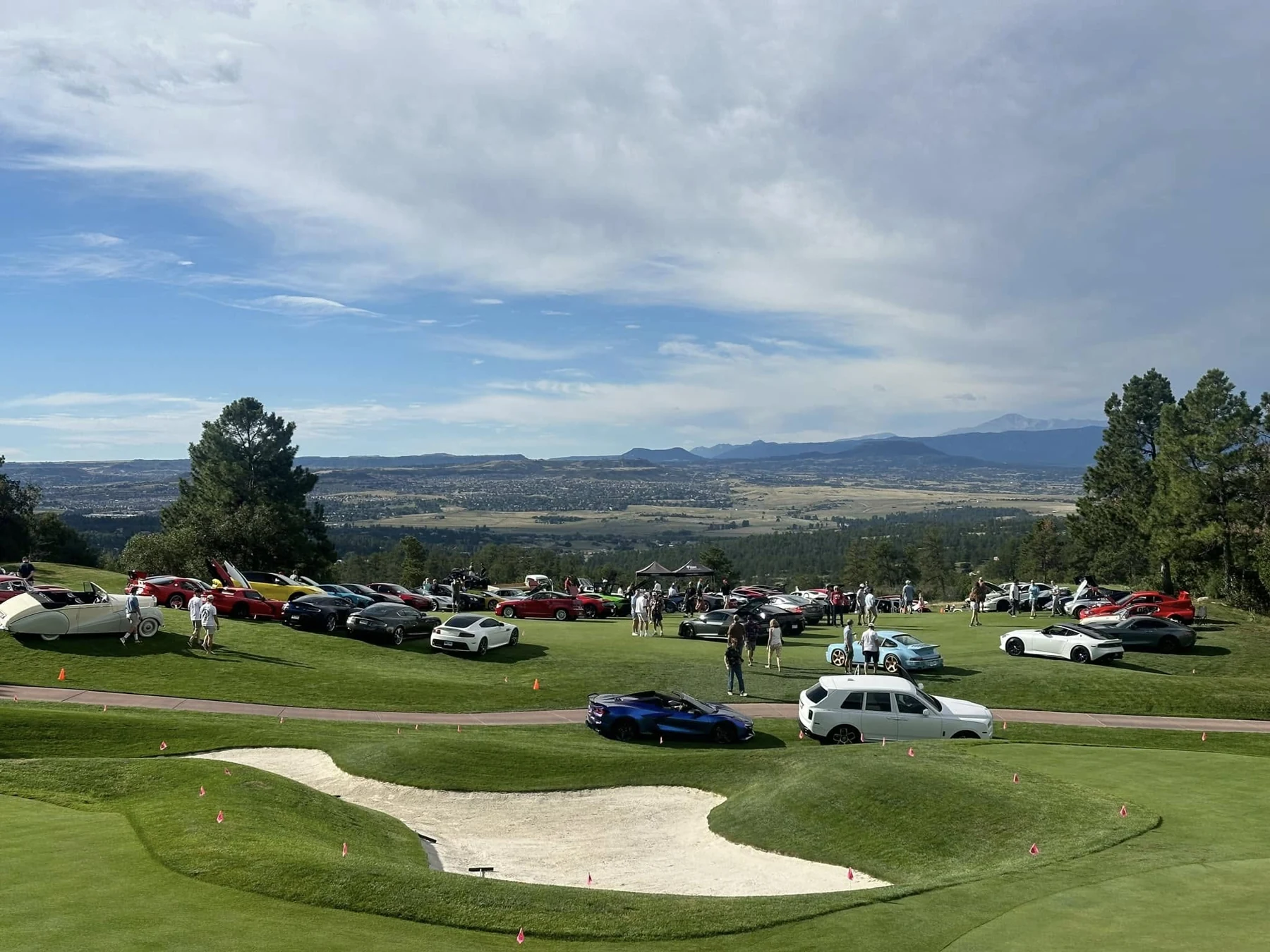 An automotive gathering overlooking Colorado mountains